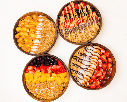 Overhead view of four acai bowls with colorful toppings at Golden Juicery