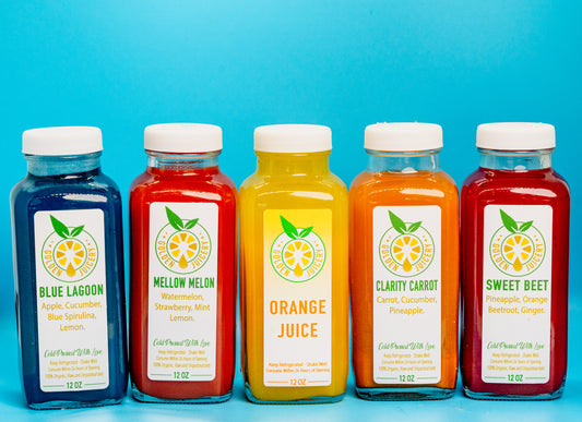 Five cold-pressed juice bottles lined up at Golden Juicery