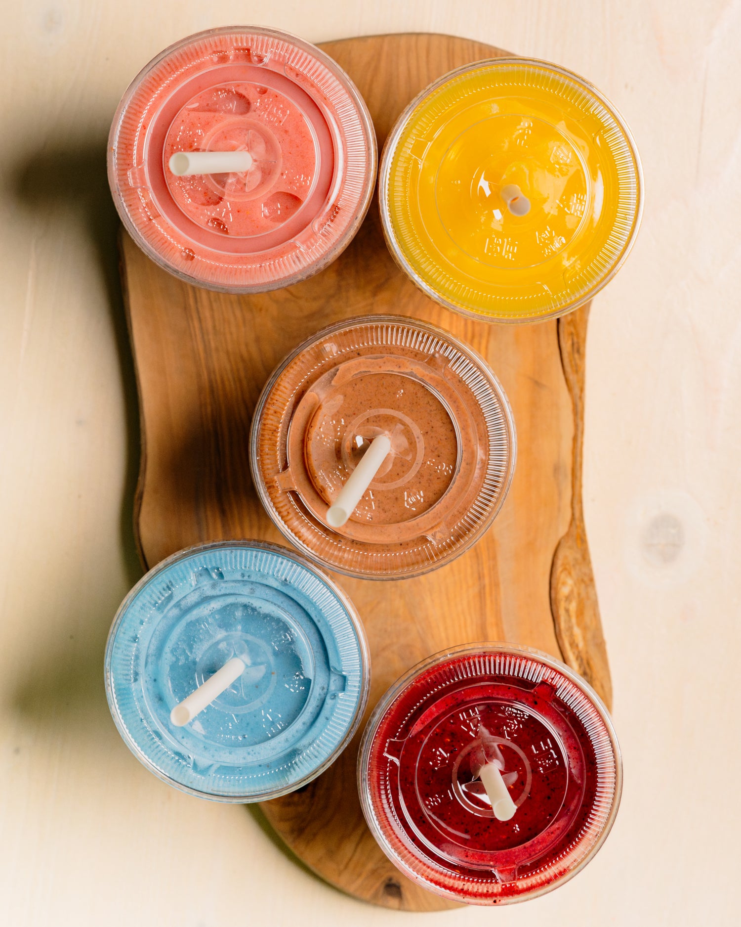 Five colorful smoothies from Golden Juicery laid out for breakfast in Jupiter FL