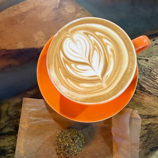 Latte with rosetta art and a protein ball at Golden Juicery